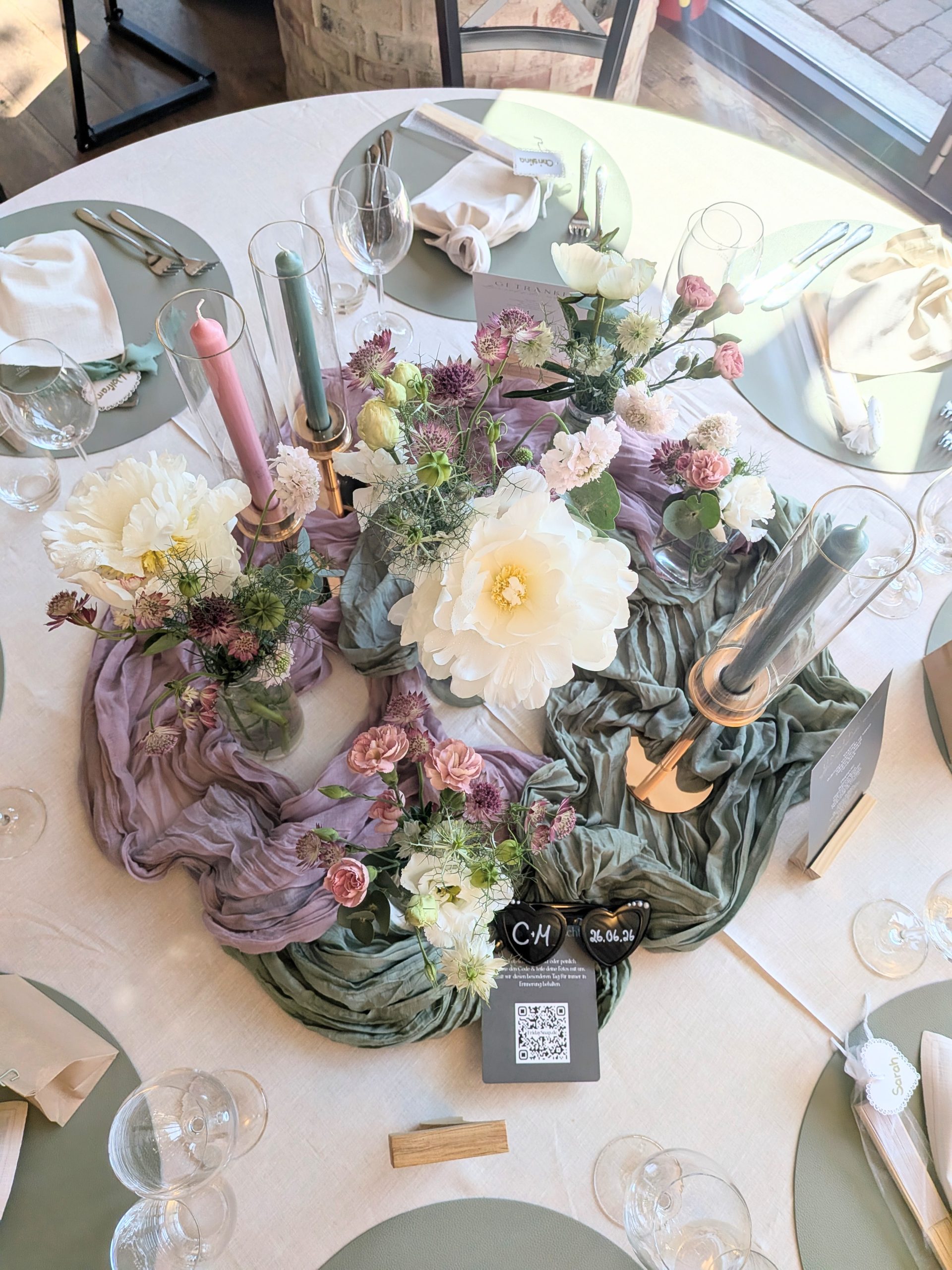 Hochzeitstisch mit floraler Dekoration in Rosa, Grün und Creme