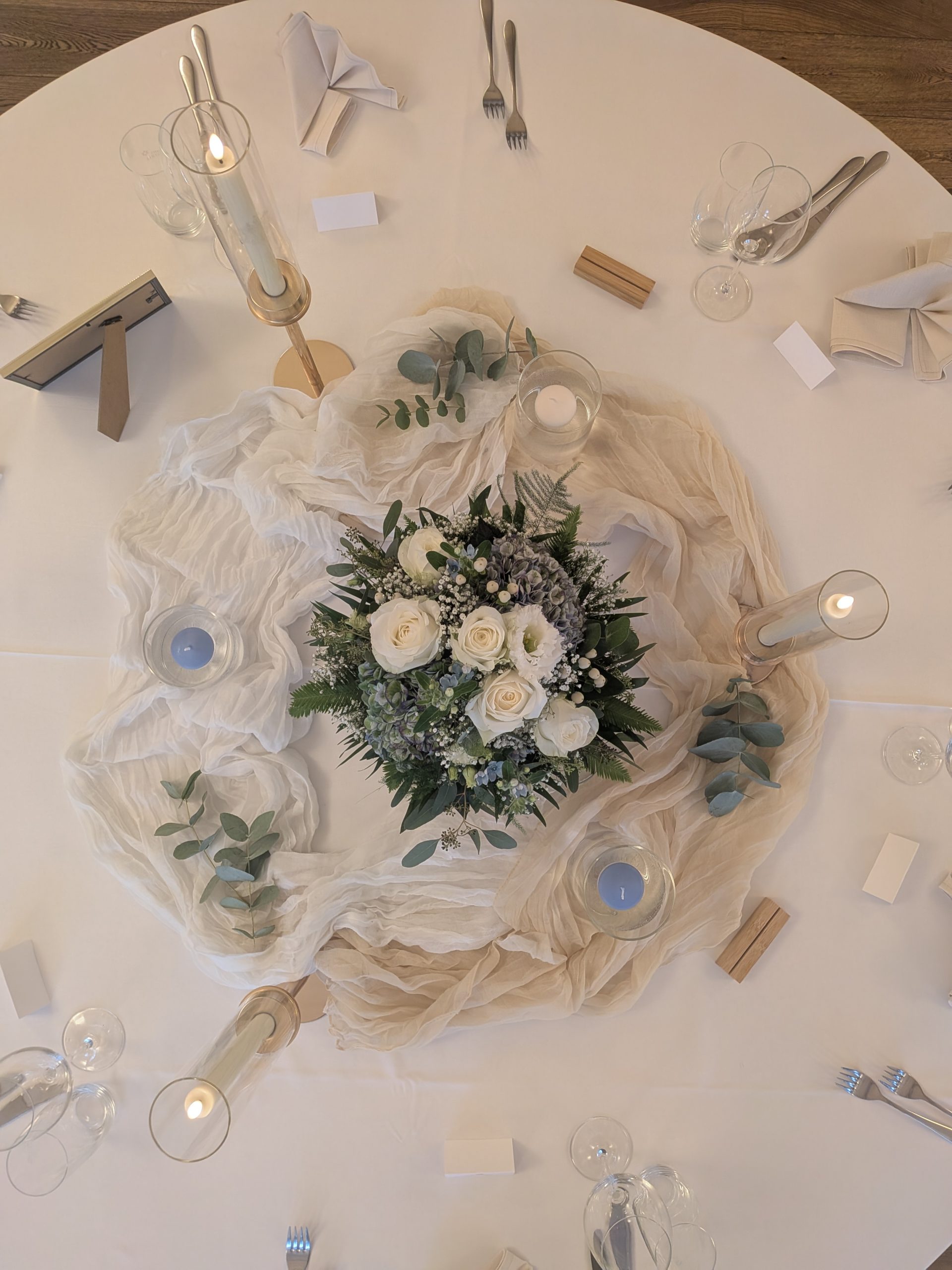 Festlich dekorierter Hochzeitstisch mit Blumenarrangement, Kerzen und Eukalyptus